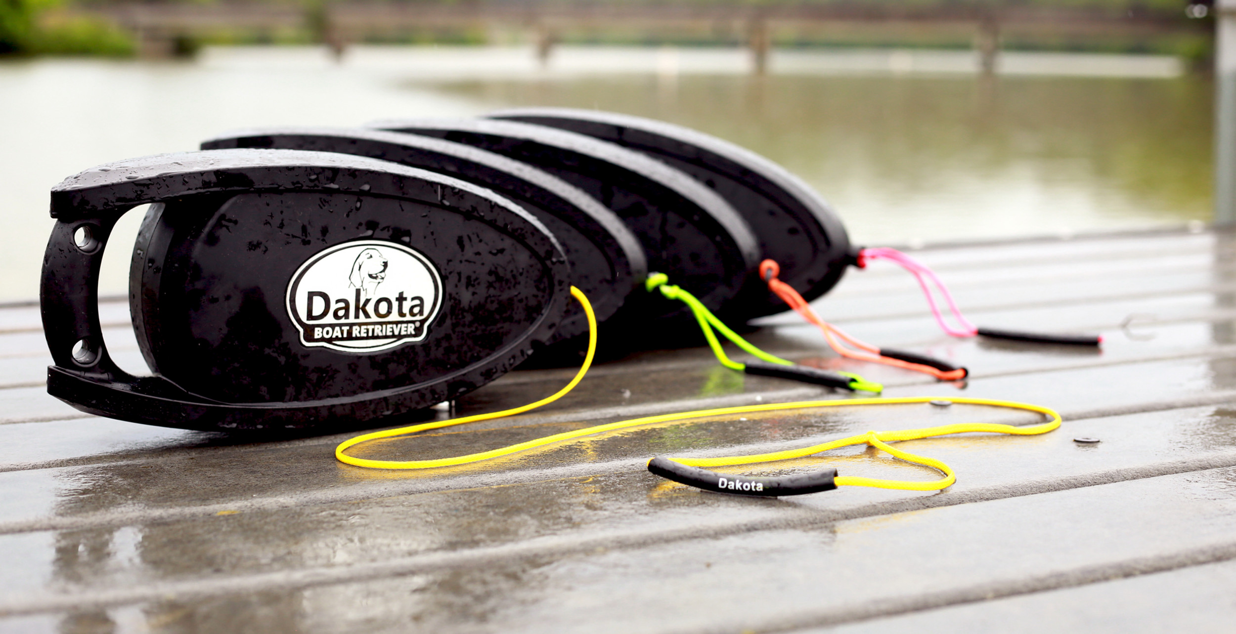 Dakota Boat Retriever units on a wet dock showing the black retriever body and colored retrieval cords