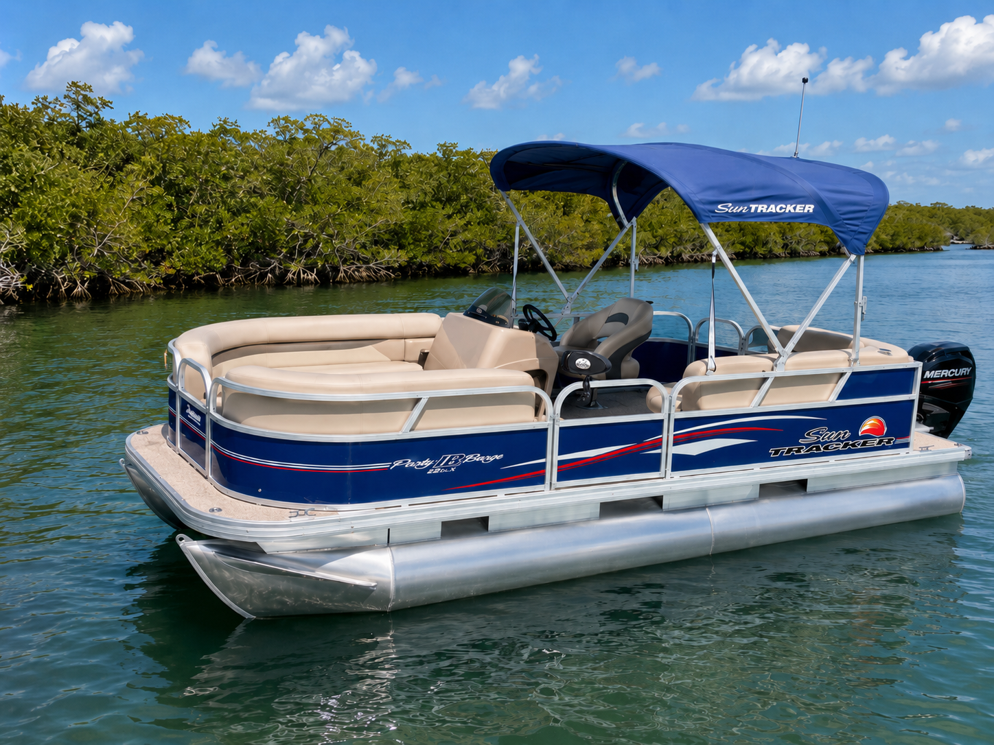 Sun Tracker Party Barge pontoon in saltwater near mangroves with a Dakota Boat Retriever mounted on the rail